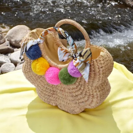 Kanya Straw Pom Pom Handbag for Summer & Travel with colourful poms and silk handle, handmade in Thailand from natural straw