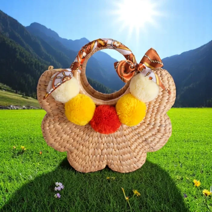 Intira Eco-Friendly Straw Bag for Bright Summer Days with pom poms and orange scarf, handmade from natural straw in Thailand