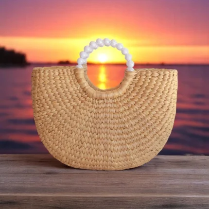 Noppamas straw raffia tote bag with curved shape and white bead handle, handmade from water hyacinth