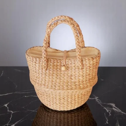 Among vegan raffia straw bag with braided handles and button closure.