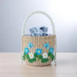 Malai Handwoven Thai Floral Drawstring Straw Bag With Blue Embroidered Flowers