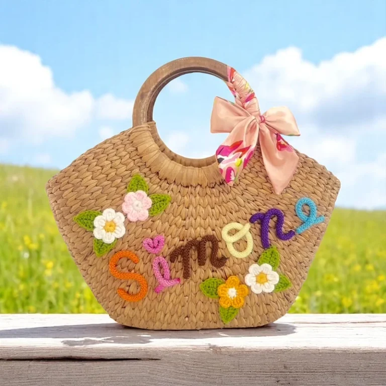 Handwoven personalised straw tote bag with colourful floral embroidery and custom name detail, eco-friendly and handmade in Thailand.