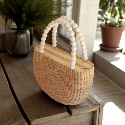 Tassanee Oval Straw Bag With White Bead Handles On Wooden Table